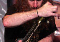 Musician passionately playing electric guitar on stage.